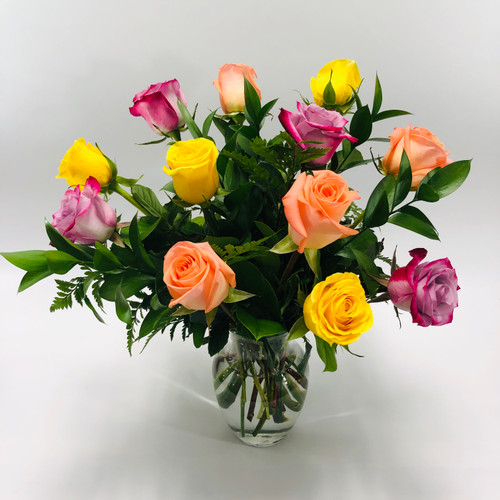 Rainbow of Roses showcases a variety of 12 multi-colored short stem roses beautifully arranged in a vase in Rockville MD, Palace Florists